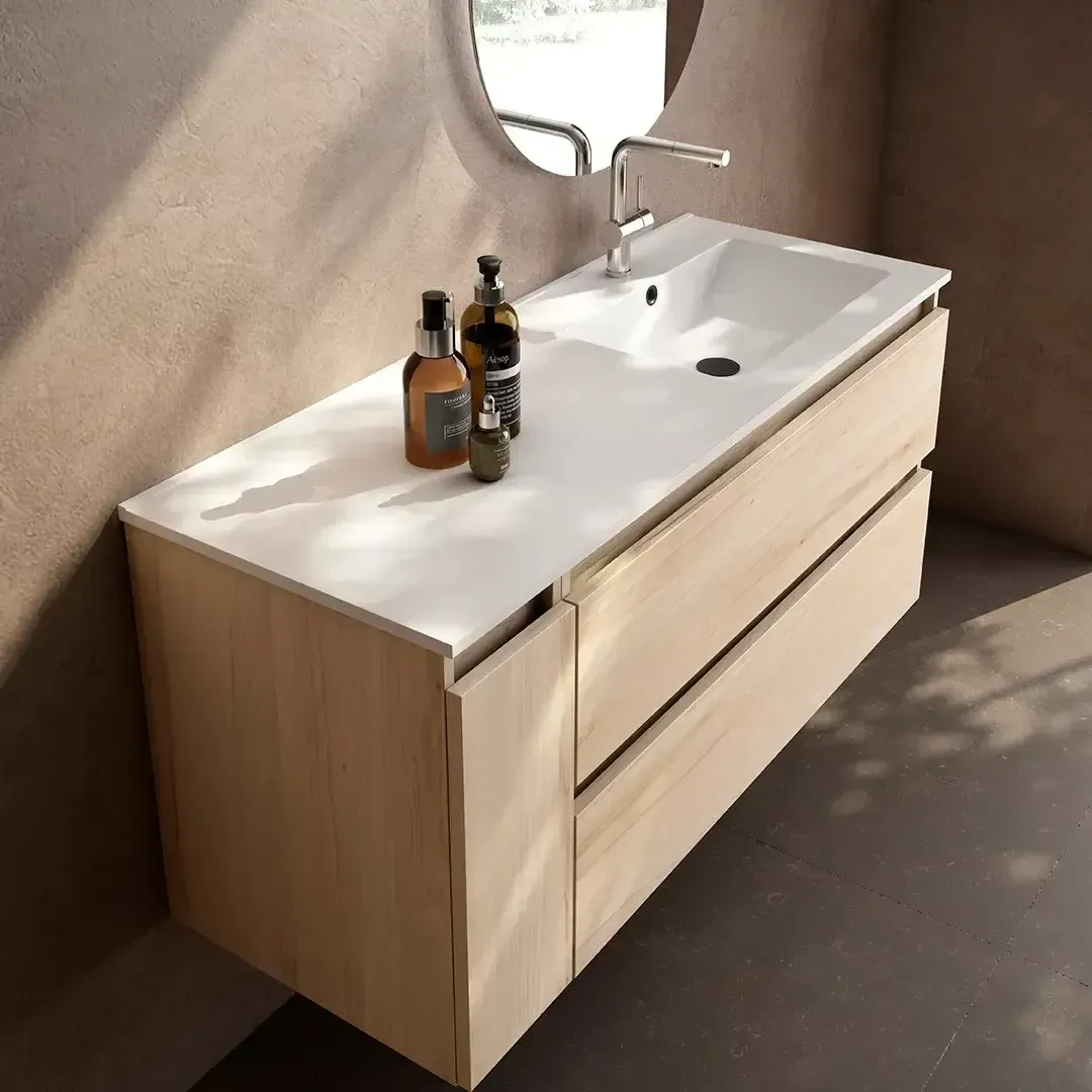 Tocador de madera con encimera y lavabo blancos, dos cajones y espejo redondo.