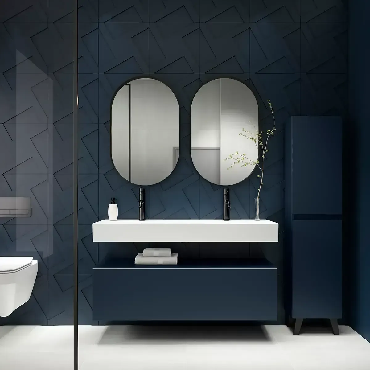 Baño azul moderno con lavabos dobles, espejos ovalados y un mueble alto.