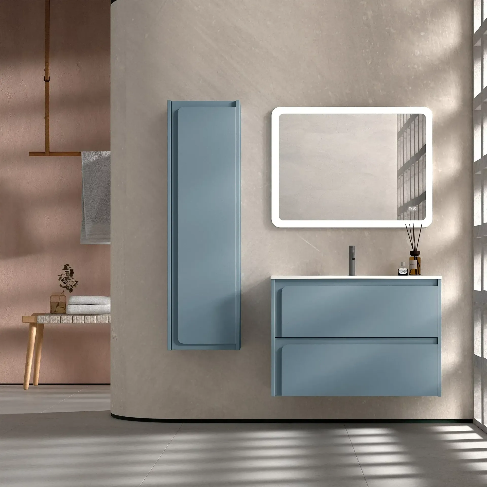 Tocador de baño azul moderno, armario alto y espejo iluminado sobre una pared neutra.