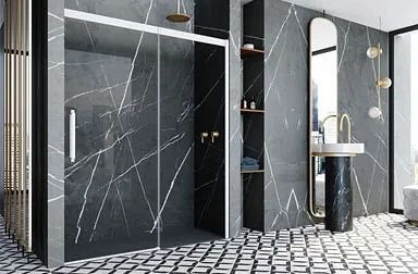 Baño moderno con ducha con marco negro, tocador flotante de madera, espejo circular, paredes grises y un inodoro blanco.