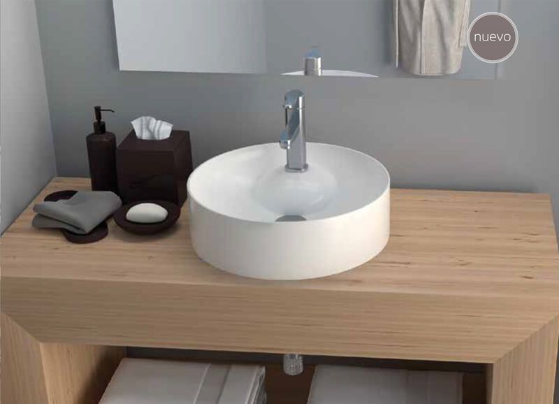 Baño con lavabo redondo blanco, encimera de madera y accesorios oscuros.