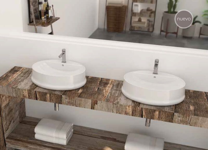 Dos lavabos ovalados blancos sobre un tocador de madera rústica en un baño, con un espejo que refleja la habitación.