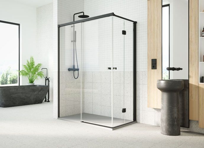 Baño moderno con ducha de vidrio con marco negro, accesorios negros y lavabo con pedestal.