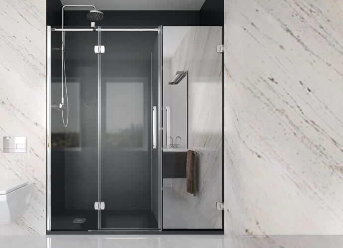 Mampara de ducha moderna con puerta de cristal, junto a pared de mármol, y lavabo.