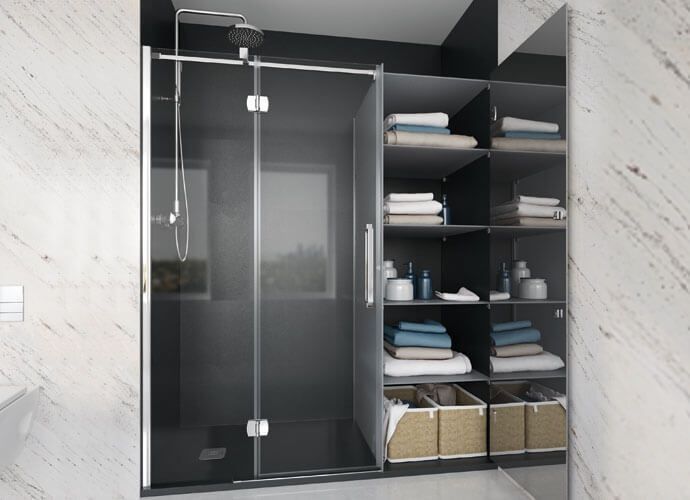 Ducha con puerta de cristal, estantería abierta adyacente con toallas y artículos de aseo, baño moderno.