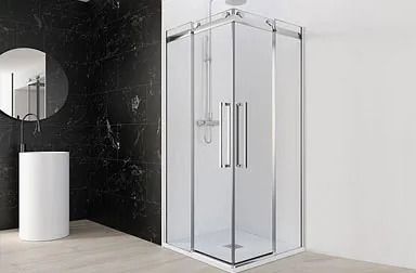 Baño moderno con ducha con marco negro, tocador flotante de madera, espejo circular, paredes grises y un inodoro blanco.