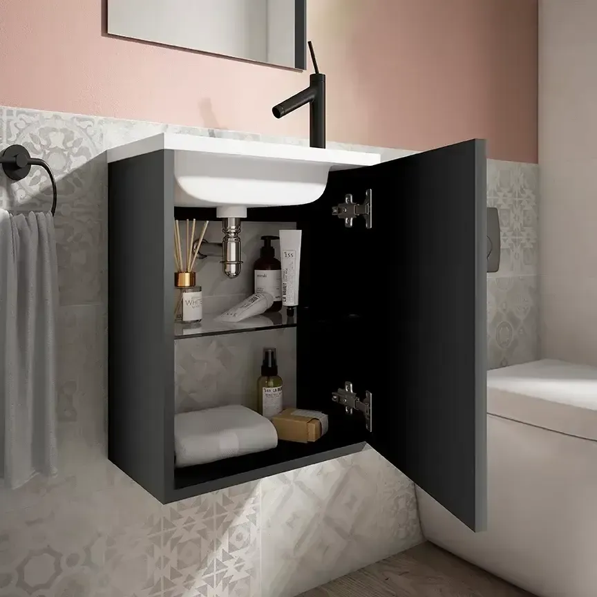 Mueble de baño de pared de color negro con puerta abierta que deja ver artículos de tocador y plomería, un lavabo blanco y un grifo negro.
