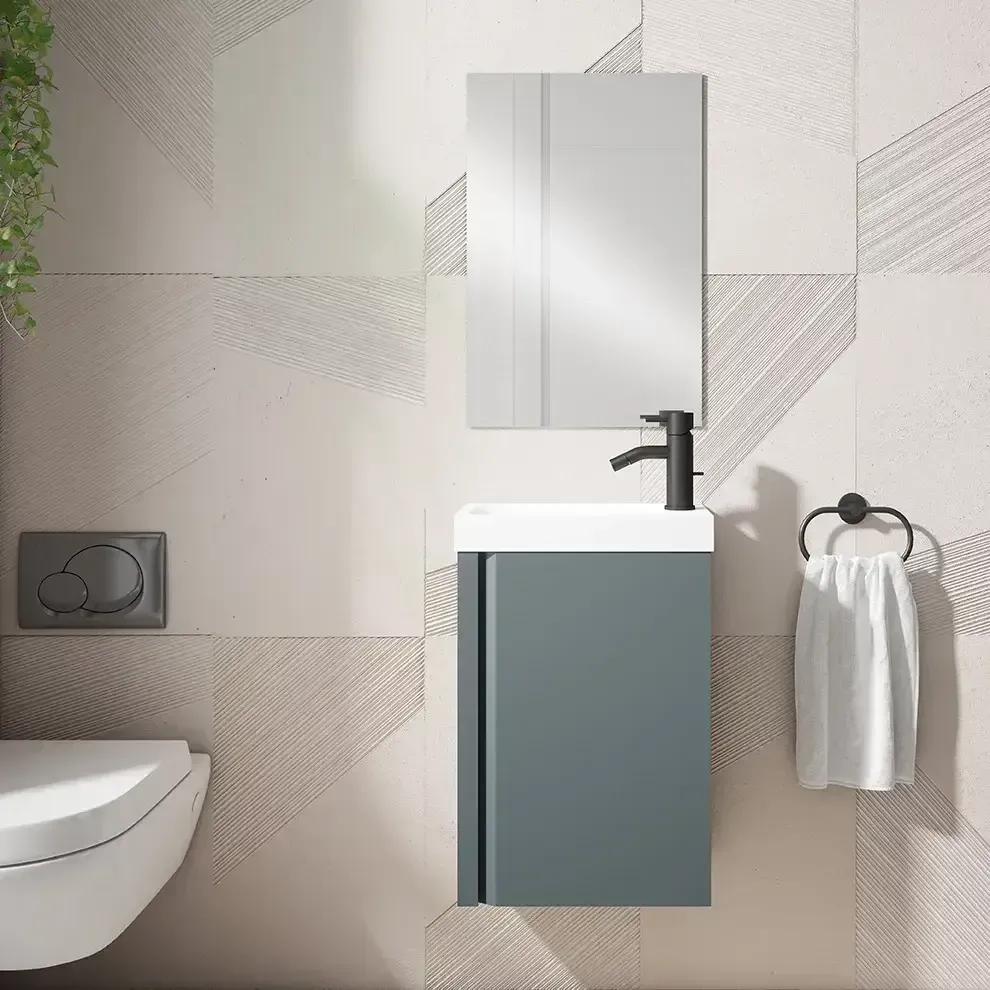 Baño pequeño y moderno con tocador gris, espejo, inodoro y toallero.