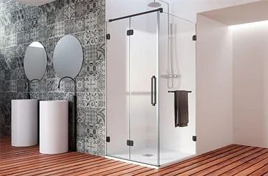 Baño moderno con ducha de cristal, dos espejos redondos y pared estampada. Suelo marrón rojizo y lavabos blancos.