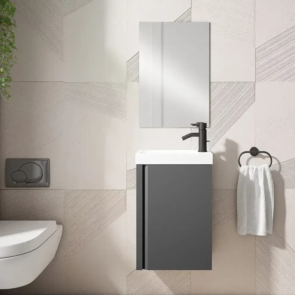 Baño moderno con tocador gris, lavabo blanco, espejo, grifo negro, toallero e inodoro montado en la pared.