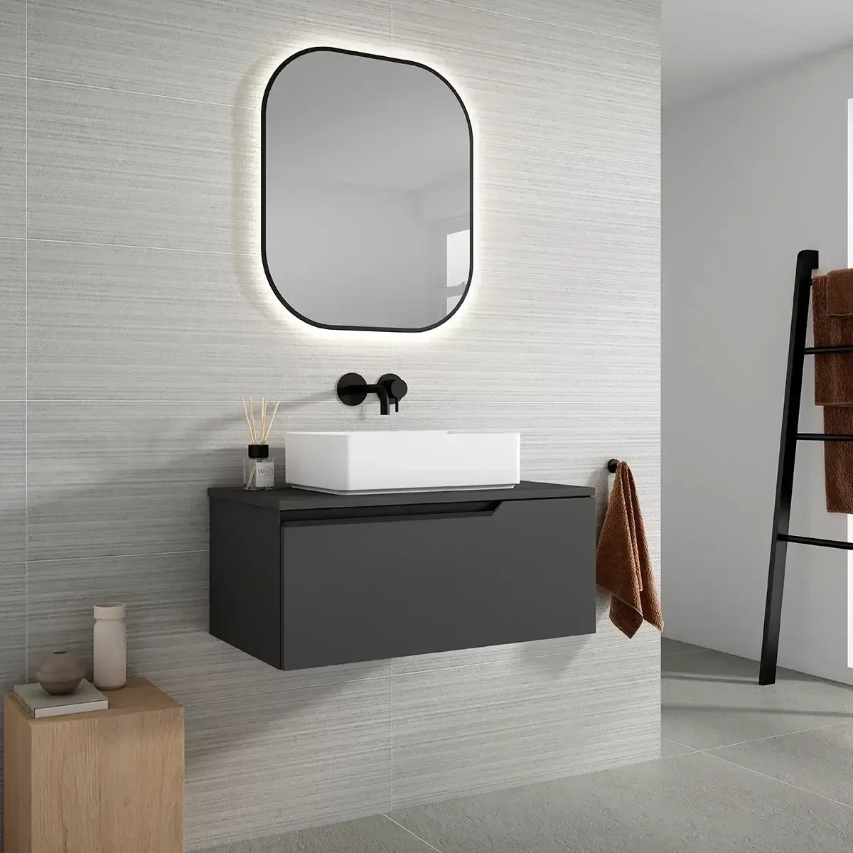 Tocador de baño gris moderno con espejo, lavabo blanco y accesorios negros.