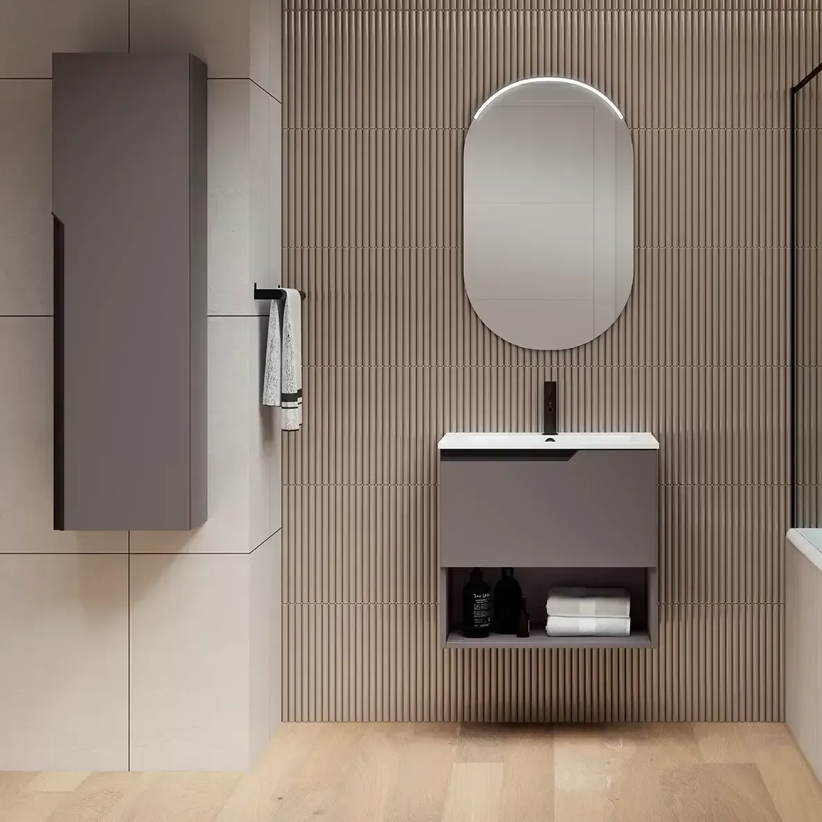 Baño moderno con tocador gris, espejo ovalado y pared de rayas verticales.
