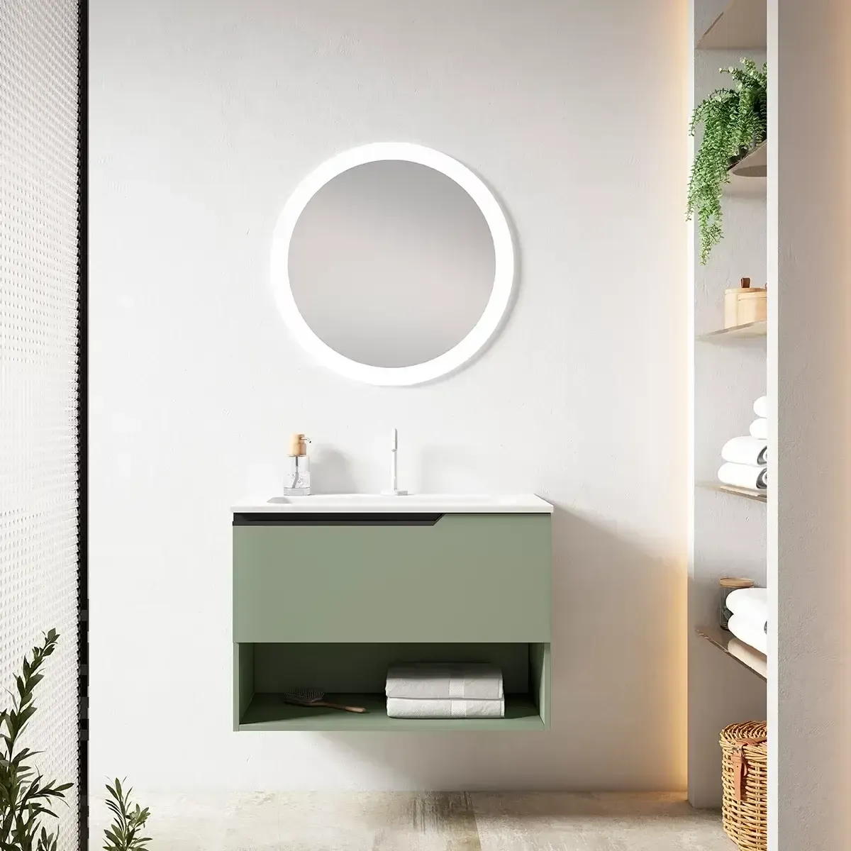 Tocador de baño verde con espejo redondo y estante abierto debajo.