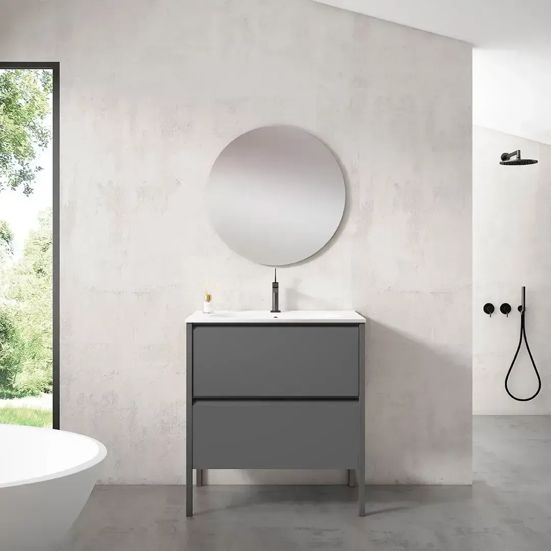 Mueble de baño color gris con espejo circular, grifería y cajones.