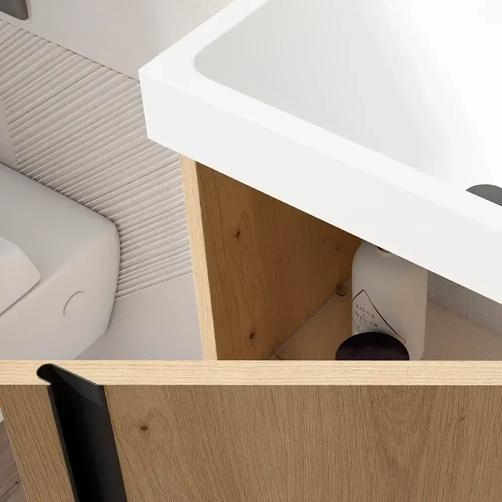 Mueble de baño con lavabo blanco, mueble de madera y tirador negro.