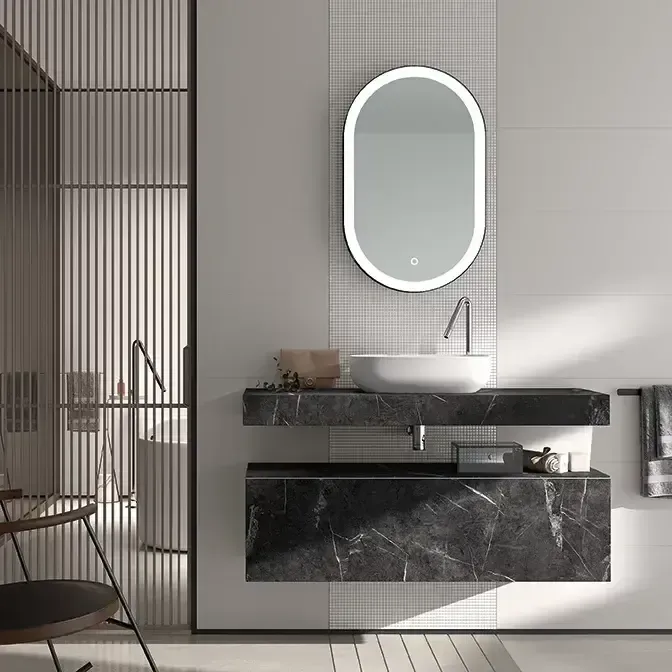 Baño moderno con tocador flotante, espejo ovalado y diseño minimalista.