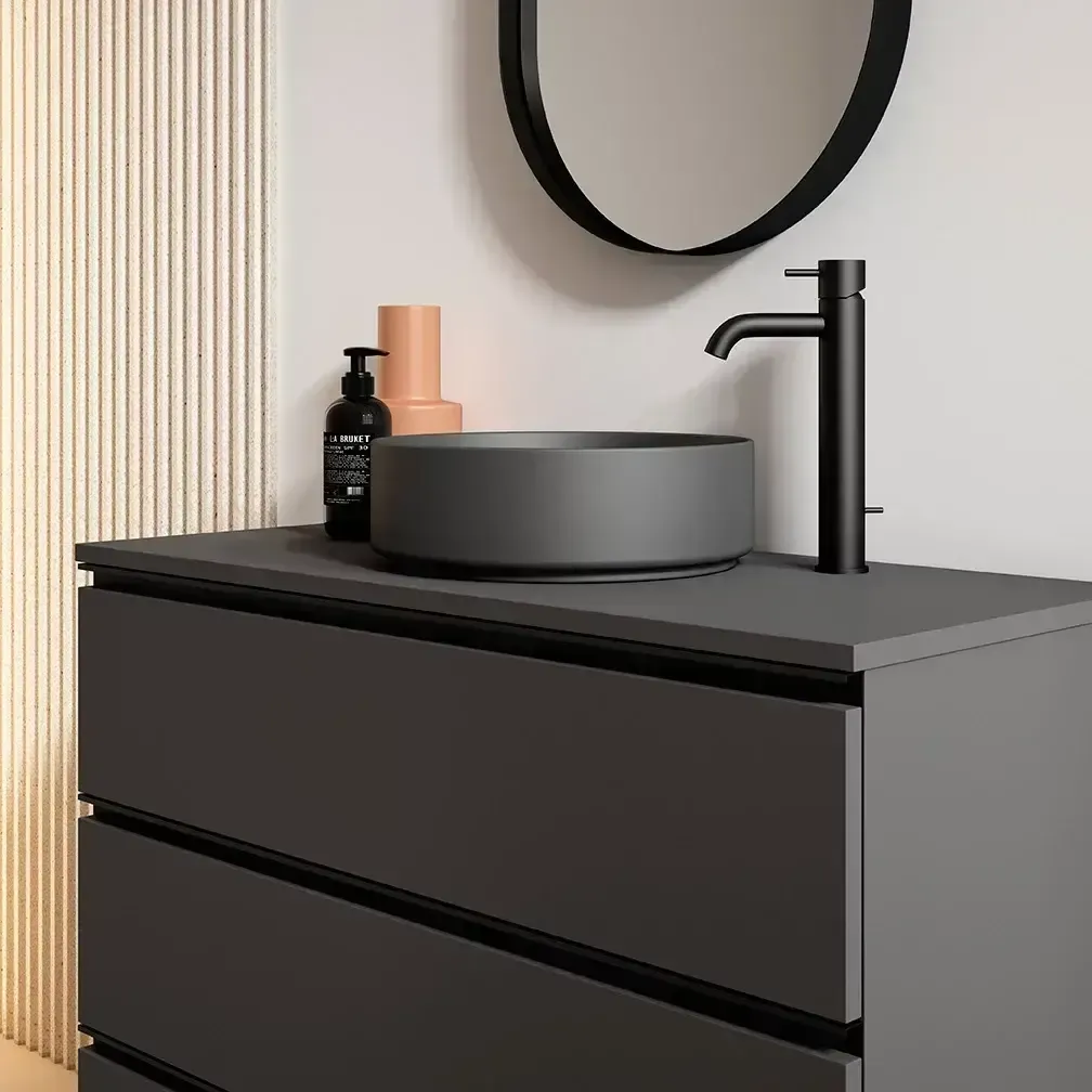 Tocador de baño gris con lavabo, grifo y espejo de color negro.