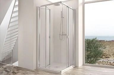Mampara de ducha de esquina con puertas de cristal transparente en un baño con ventana con vistas al mar.