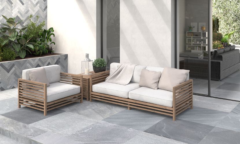 Conjunto de muebles de patio al aire libre con sofá, silla y mesa auxiliar.