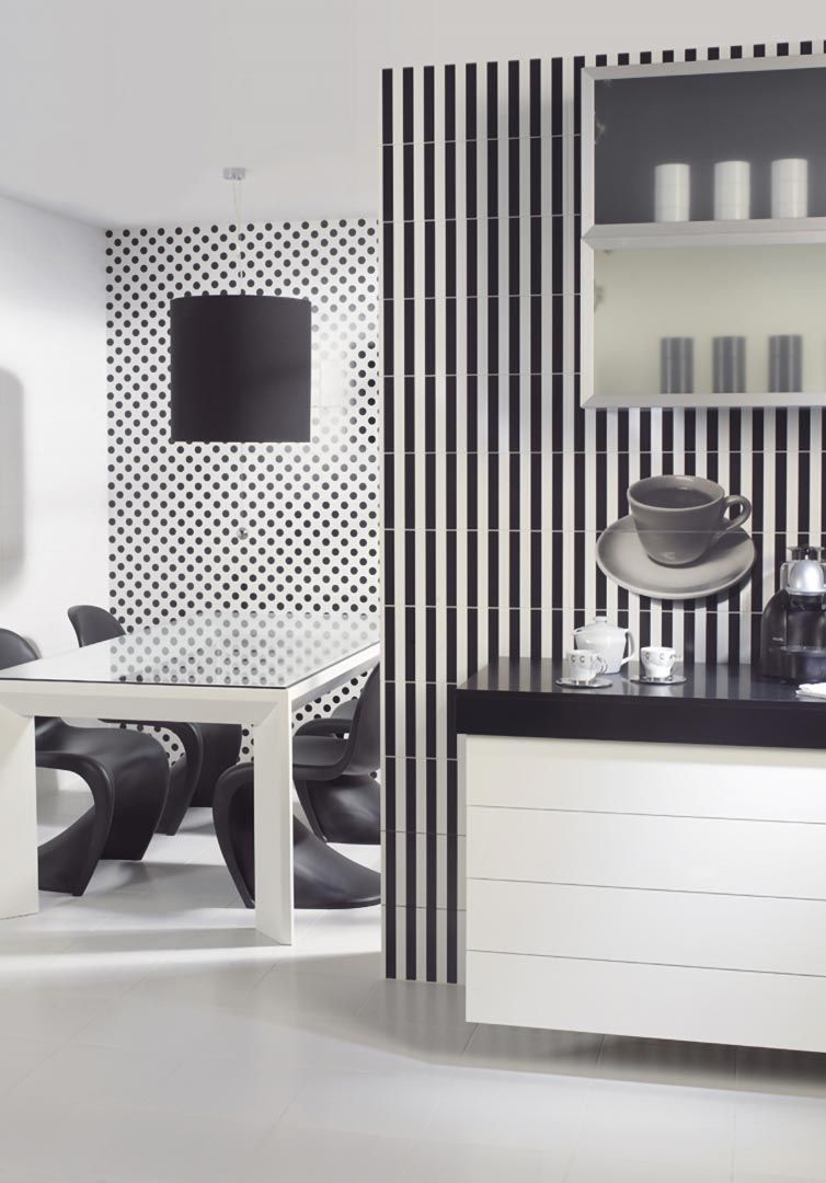 Cocina moderna en blanco y negro con paredes, encimera y armarios de azulejos estampados. También se ve una mesa de comedor.