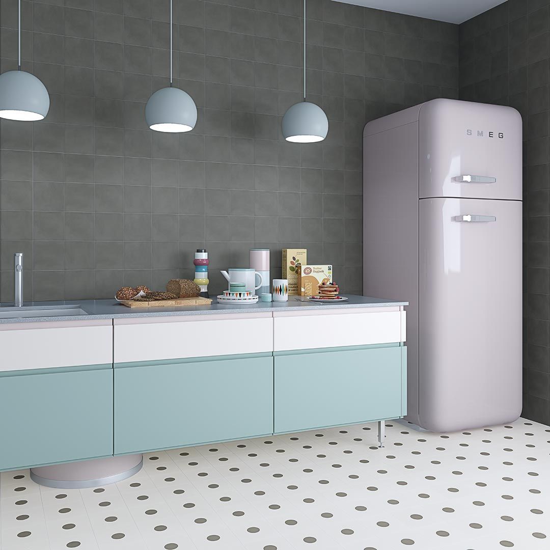 Cocina con gabinetes de color azul claro, pared gris, refrigerador retro y luces colgantes.