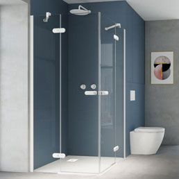 Mampara de ducha de esquina con puertas de cristal transparente y herrajes cromados sobre una pared azul.