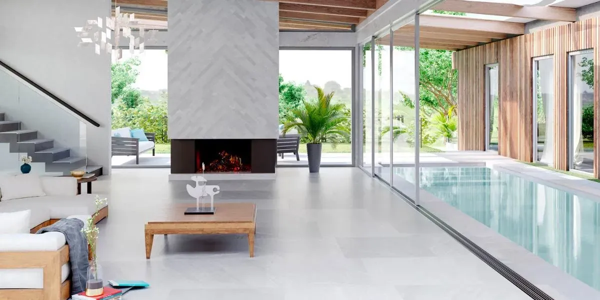 Moderna sala de estar con chimenea, piscina y ventanas de piso a techo con vista a un patio verde.