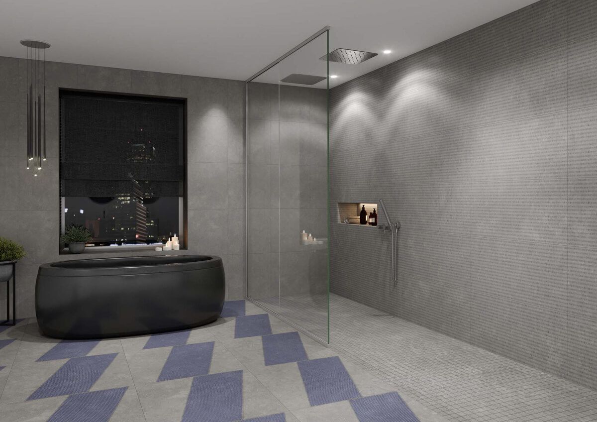 Baño moderno con paredes grises, suelo con estampado azul y gris, bañera negra y ducha de cristal.