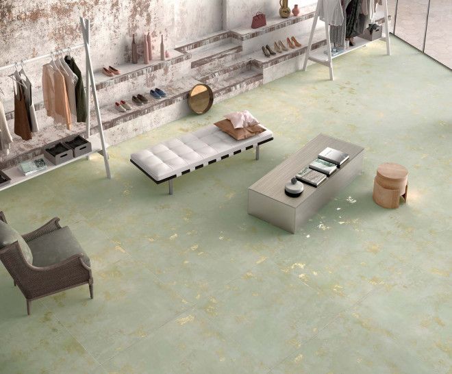 Local comercial con suelo color verde claro, percheros, asientos y estanterías con zapatos y accesorios.