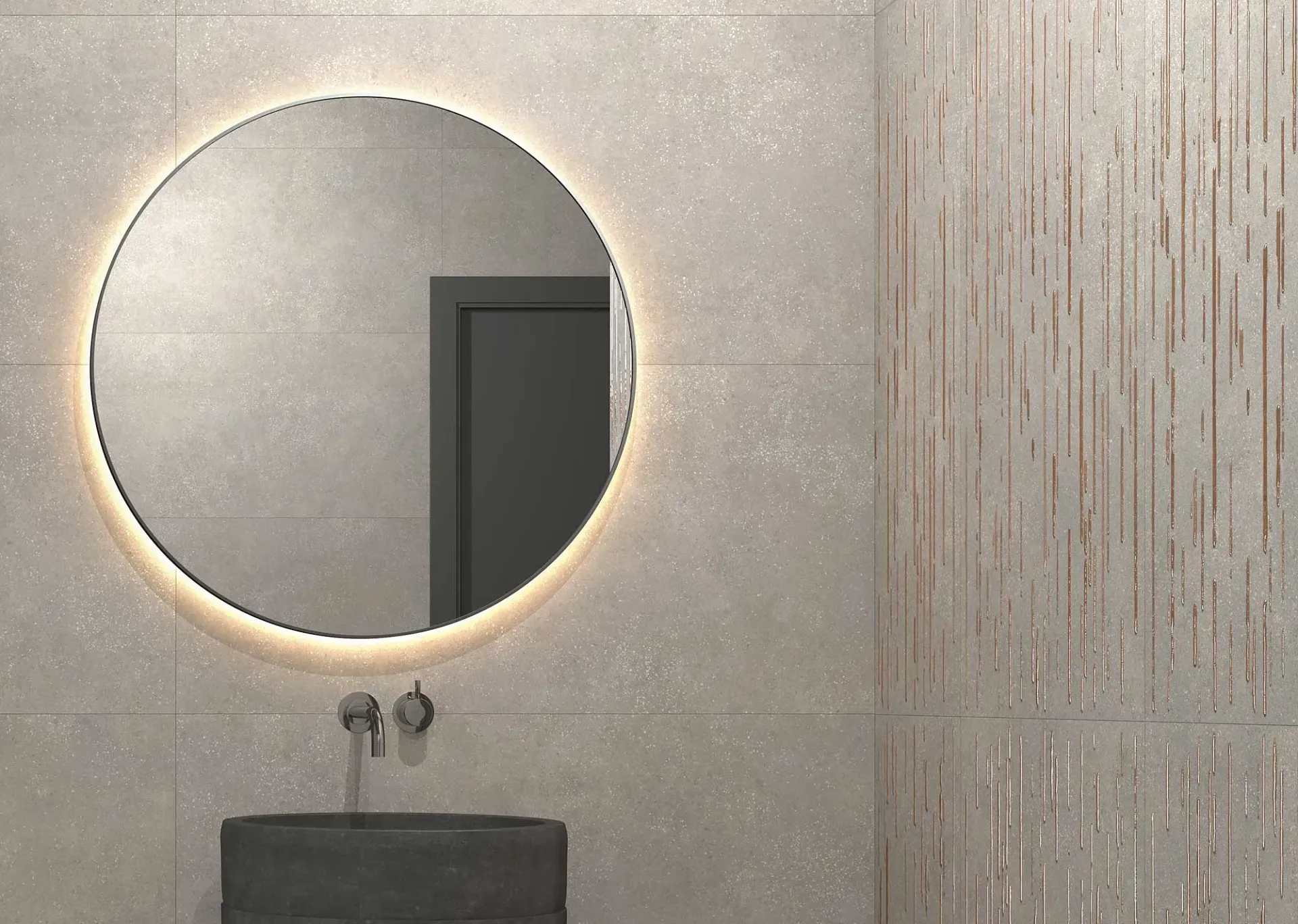Espejo redondo iluminado sobre un lavabo oscuro, contra una pared gris claro con textura. Líneas verticales decorativas a la derecha.