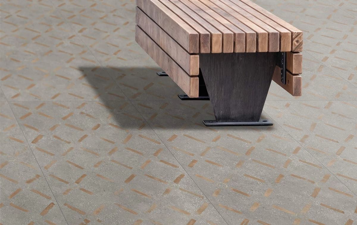 Banco de madera sobre hormigón con dibujo de rombos.