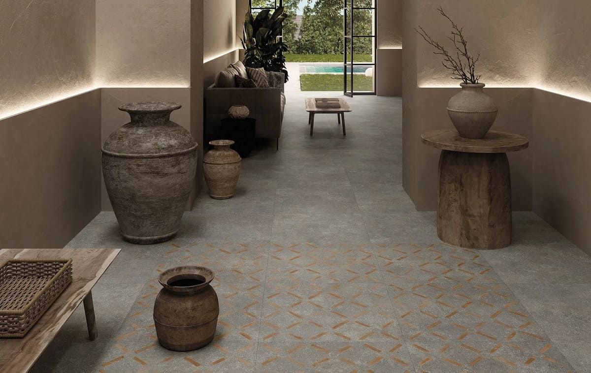 Interior de tonos neutros con suelo estampado, jarrones decorativos y vista a un espacio exterior.