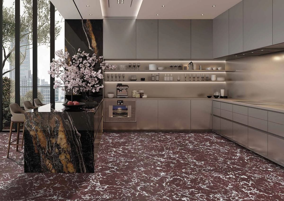 Cocina moderna con isla y gabinetes de mármol, ventanas grandes y piso estampado en rojo.