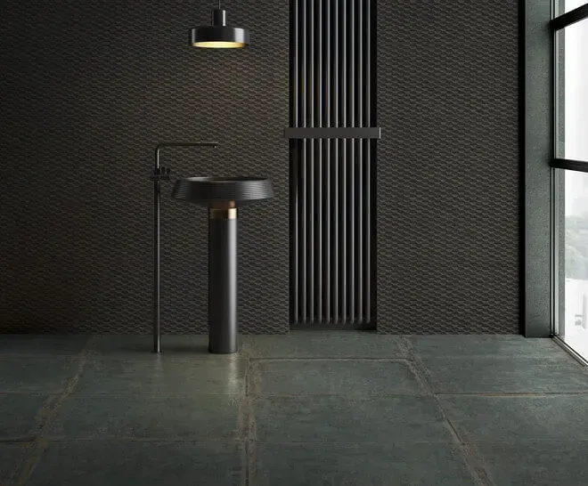Baño oscuro con lavabo negro, pared estampada y ventana grande.