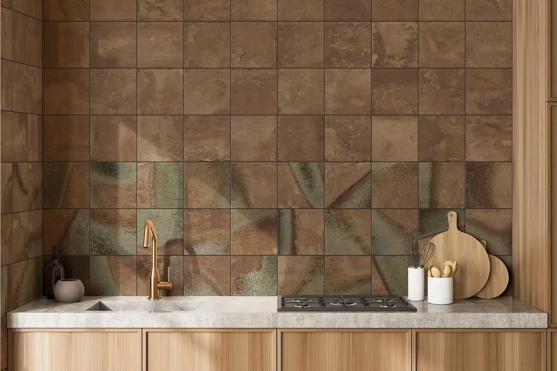 Salpicadero de cocina con azulejos de color óxido, con gabinetes y encimera de madera clara y grifo dorado.