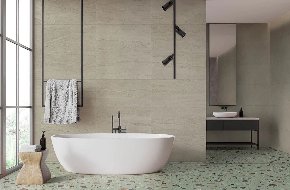 Baño moderno con bañera blanca, suelo moteado de verde y paredes de color verde claro.