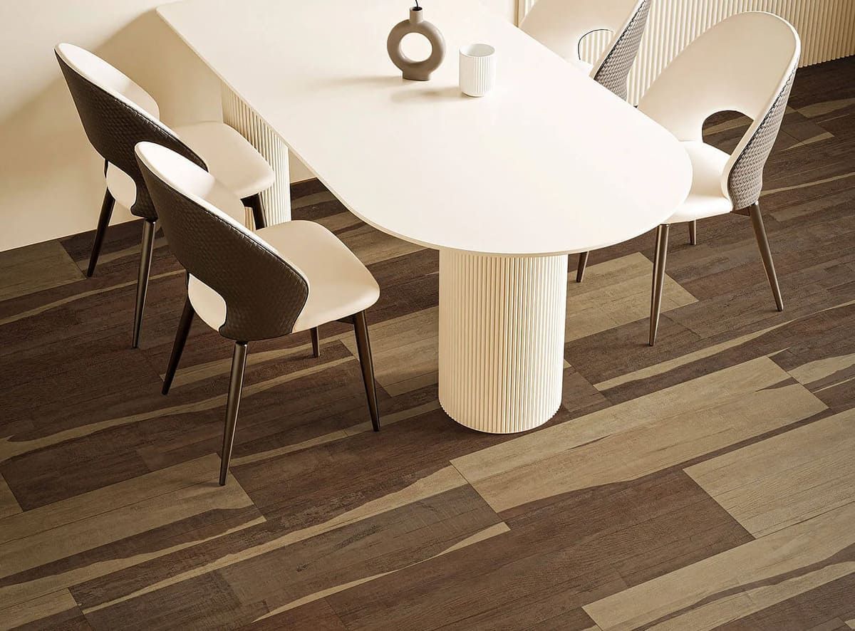 Mesa de comedor con tapa ovalada blanca, cuatro sillas y alfombra marrón estampada.