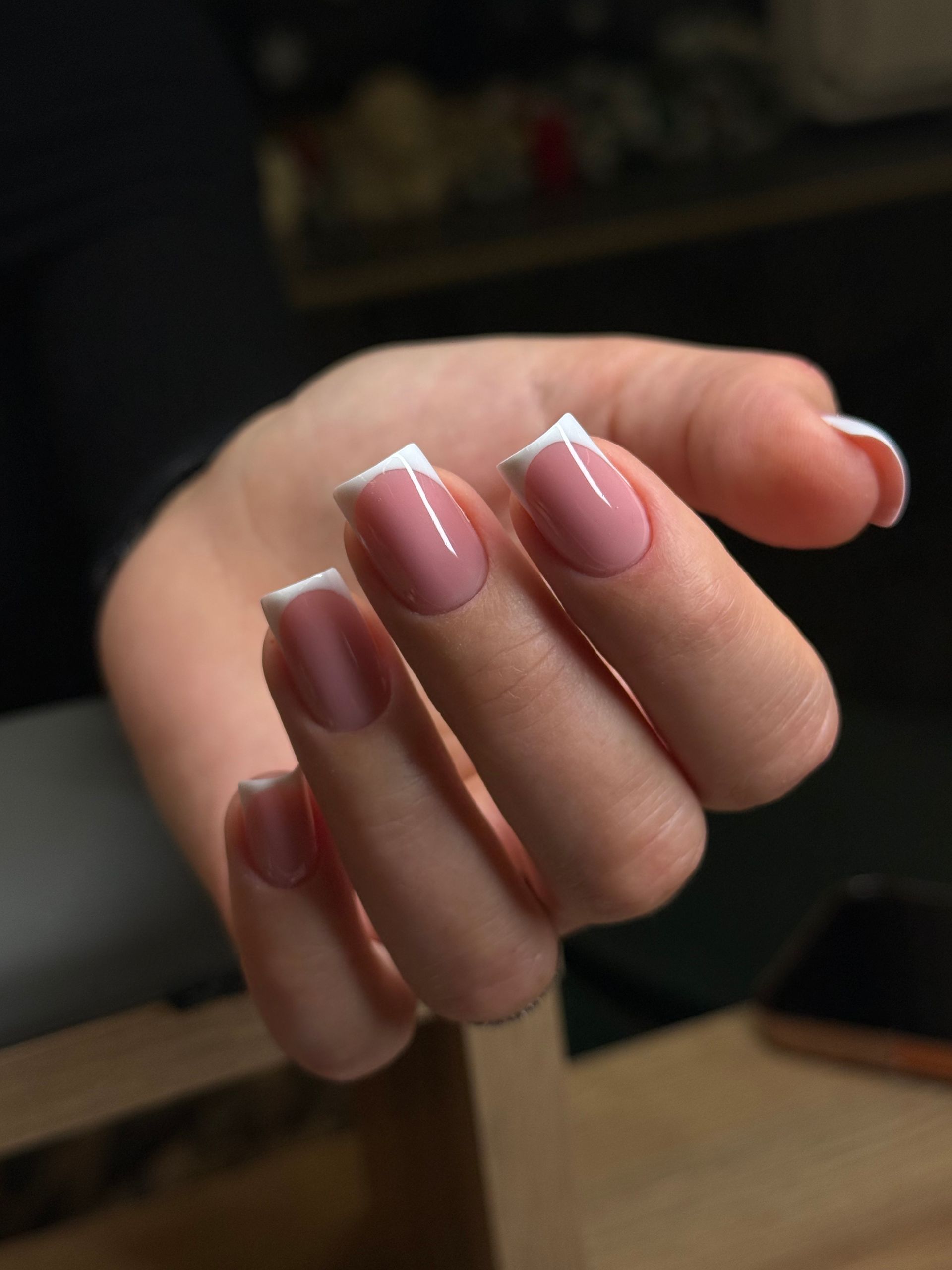Hände mit dunkelbraunem Nagellack und einem silbernen Ring.