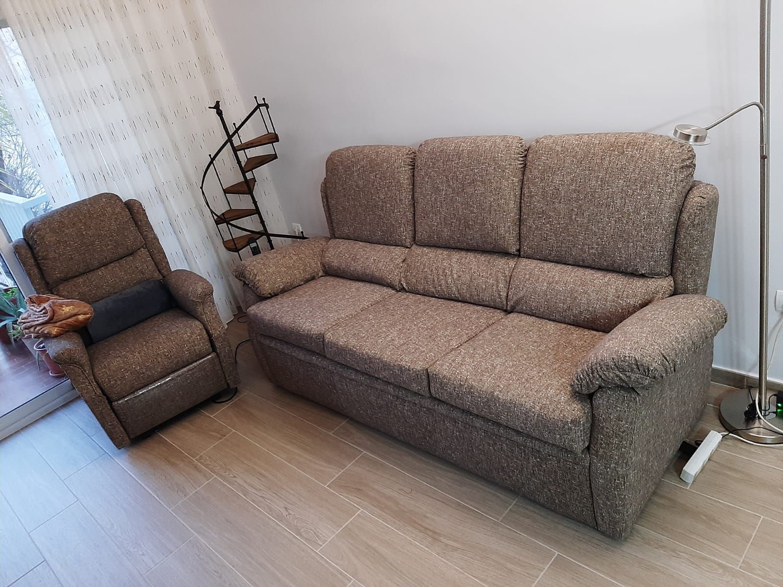 Una sala de estar con un sofá, una silla y una lámpara.