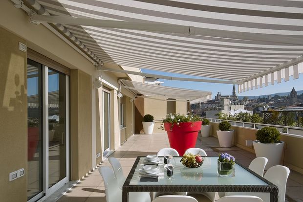 Un patio con una mesa y sillas debajo de un toldo.