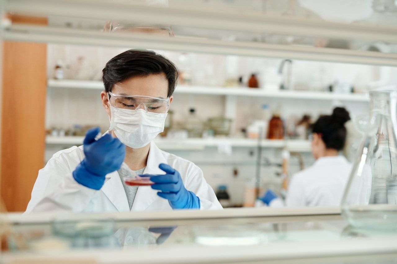 Un científico usa una máscara y guantes mientras trabaja en un laboratorio.