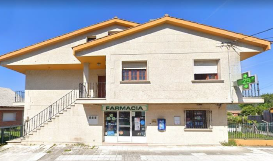 Una farmacia con una cruz verde al costado.