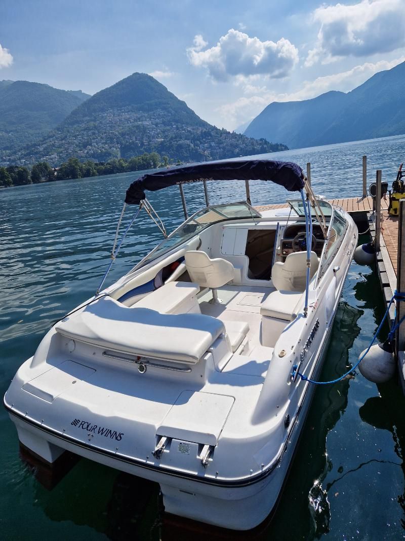 Una barca bianca è attraccata a un molo su un lago.