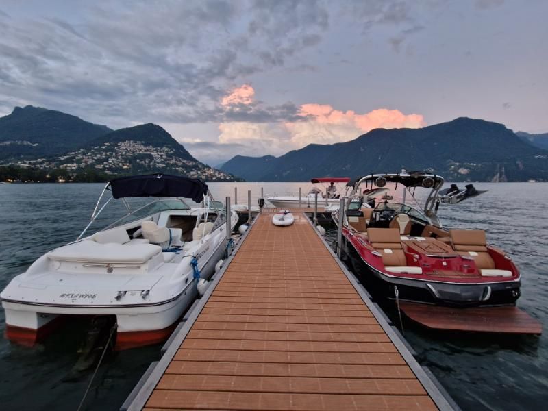 Due barche sono attraccate a un molo con le montagne sullo sfondo