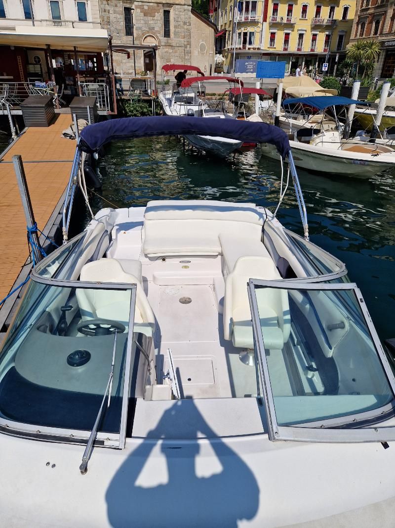 Una barca bianca è attraccata al molo di un porto.