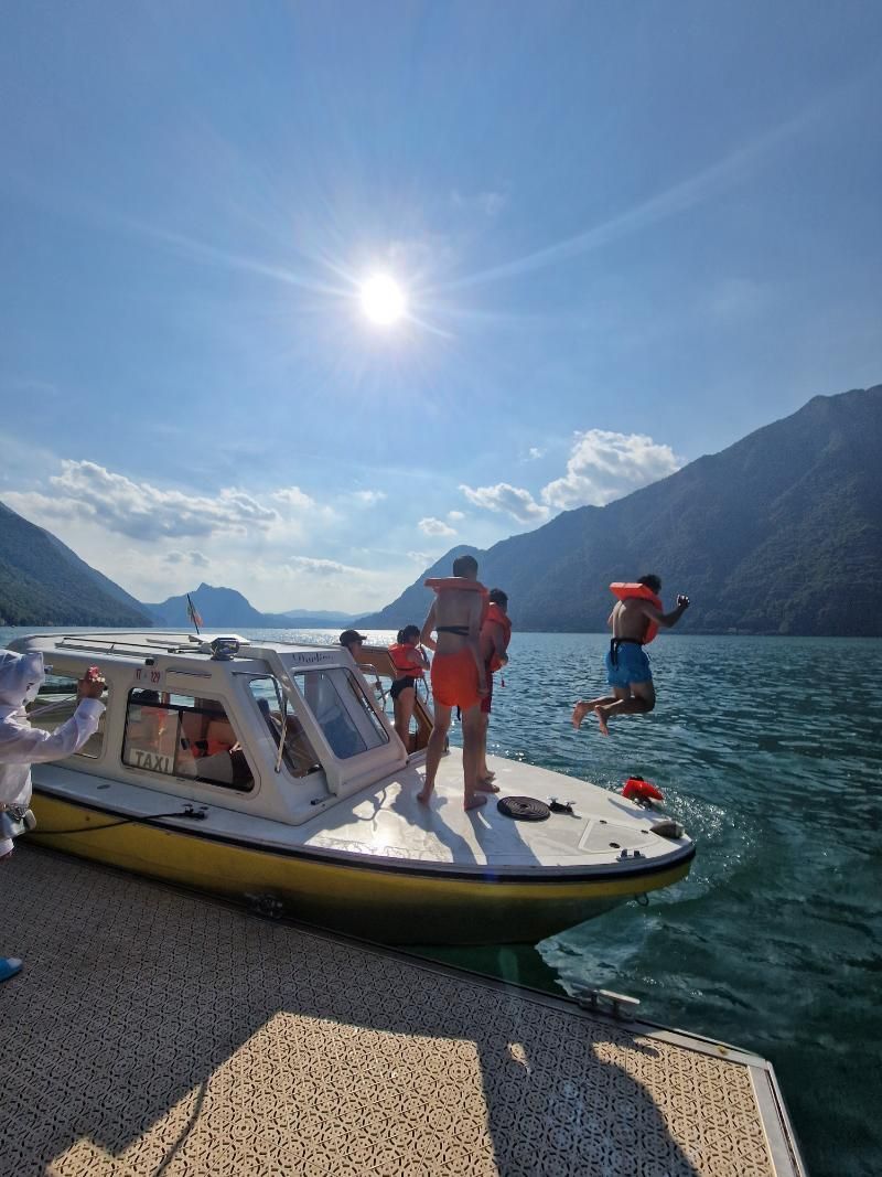 Un gruppo di persone sta saltando da una barca in un lago.