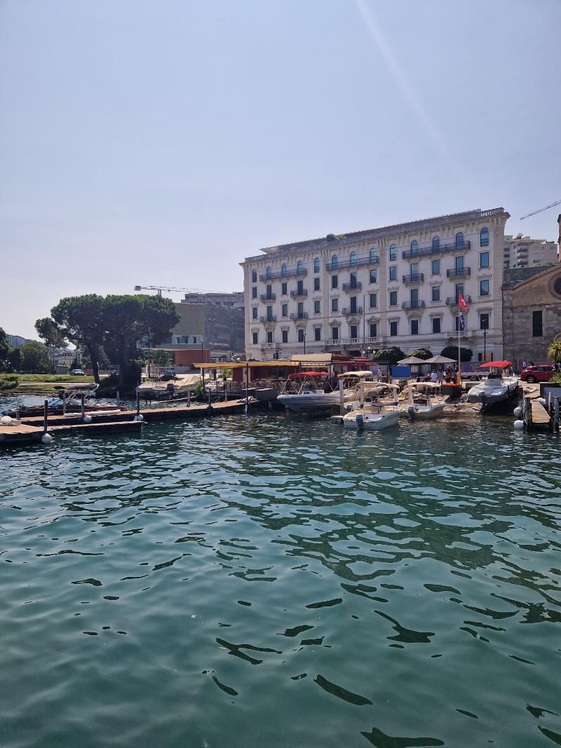 Le barche sono attraccate in un porto con un grande edificio sullo sfondo.