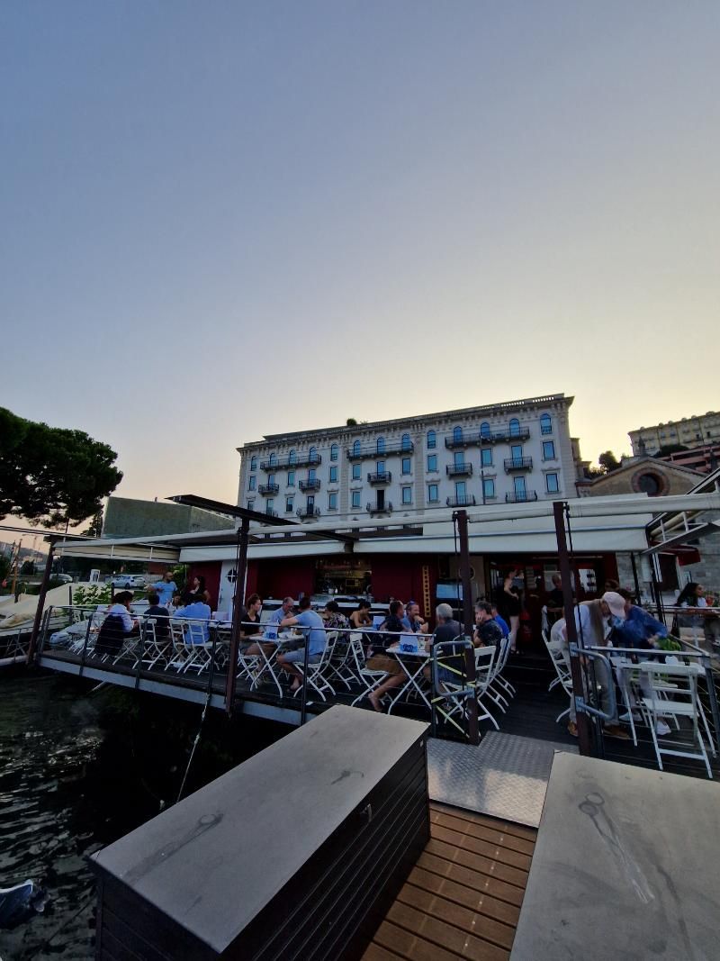 Un gruppo di persone è seduto ai tavoli fuori da un ristorante.