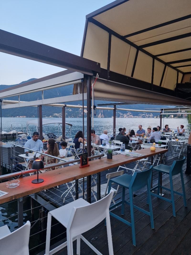 Un gruppo di persone è seduto ai tavoli di un ristorante.