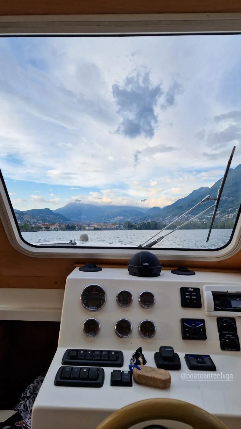 Una vista di un lago dalla cabina di pilotaggio di una barca.